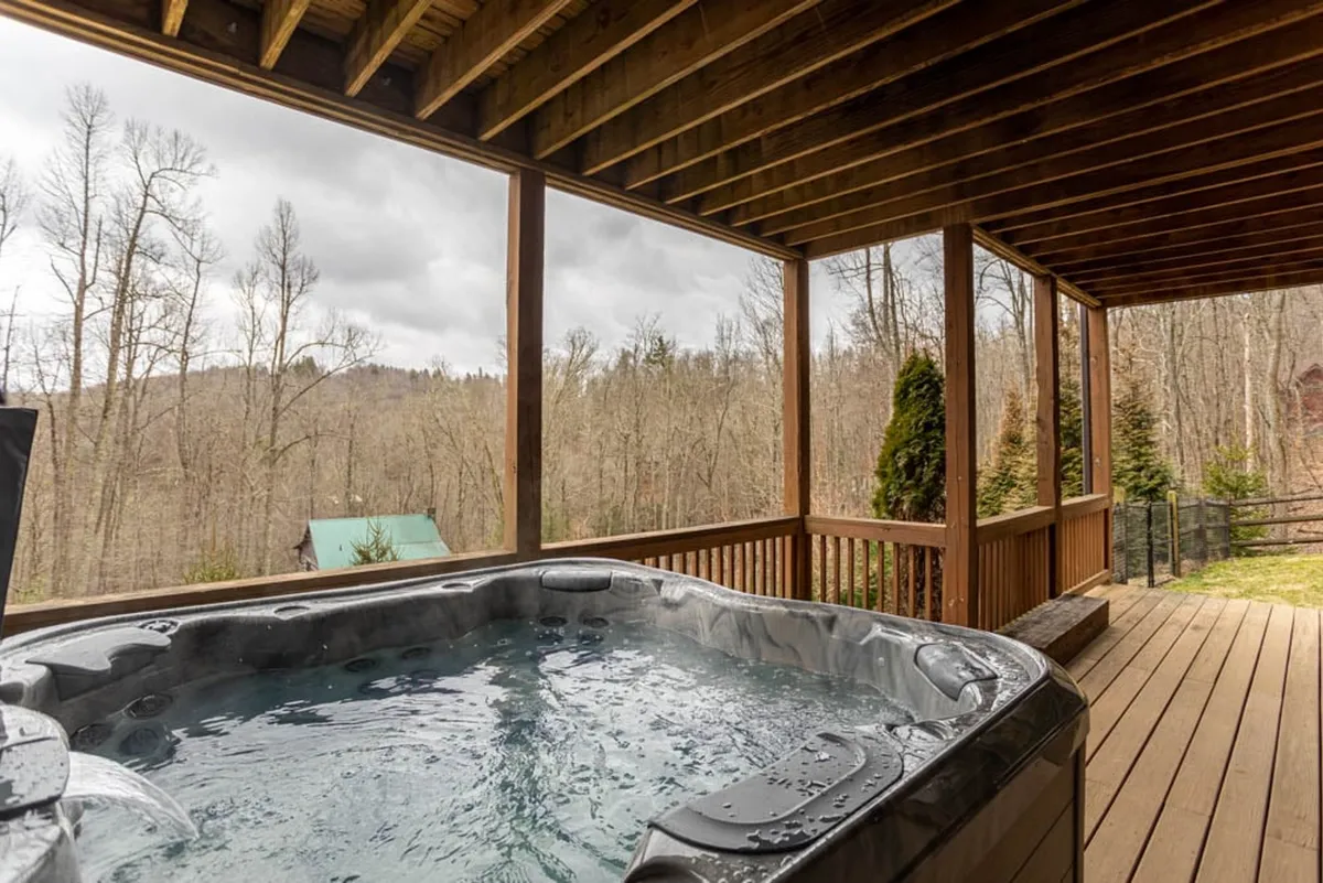 An outdoor hot tub set on a wooden deck, surrounded by lush forest views. The scene invites relaxation, with the bubbling hot tub promising a soothing soak after a day of adventure.